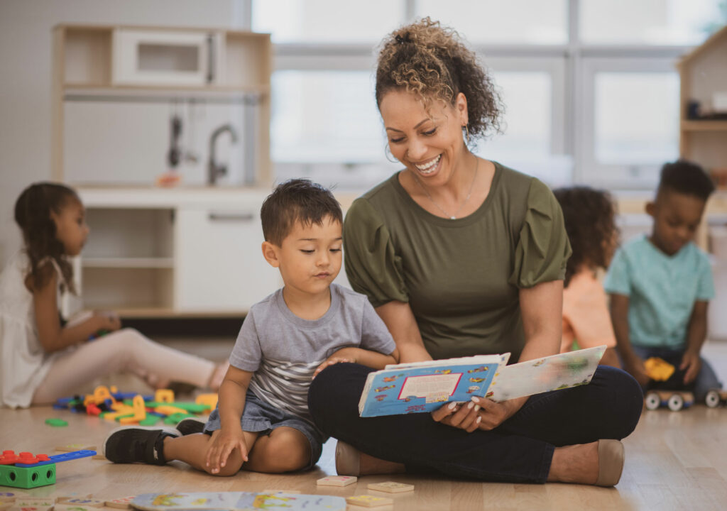 A reading teacher introduces a very young student to a book