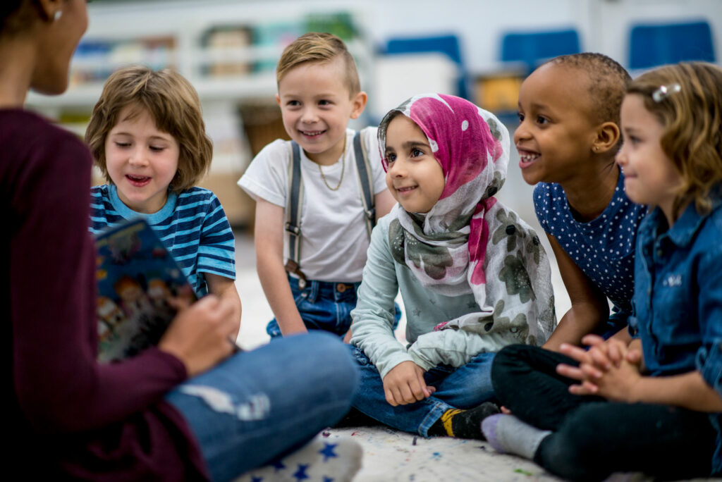 A teacher shares a book with a small group of children during reading time