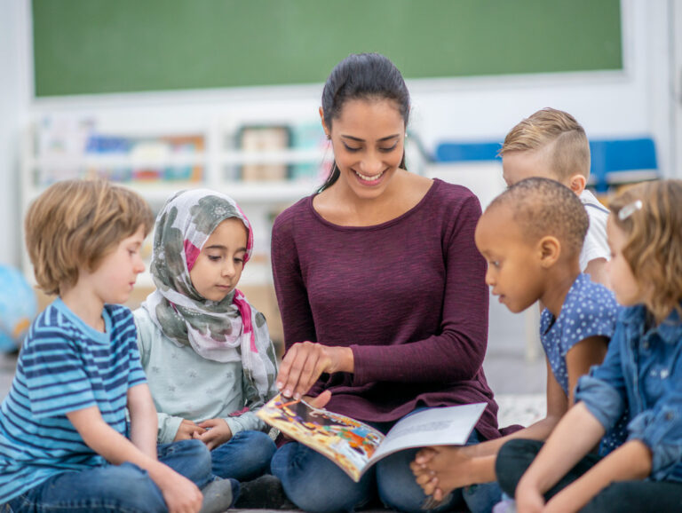 Reading specialist sharing a book with elementary school students