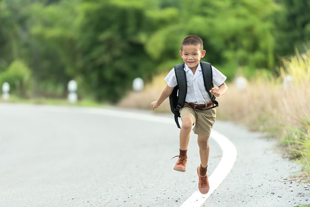 elementary school boy running happily outside