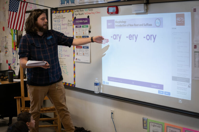 A reading teacher points out word endings on a white board