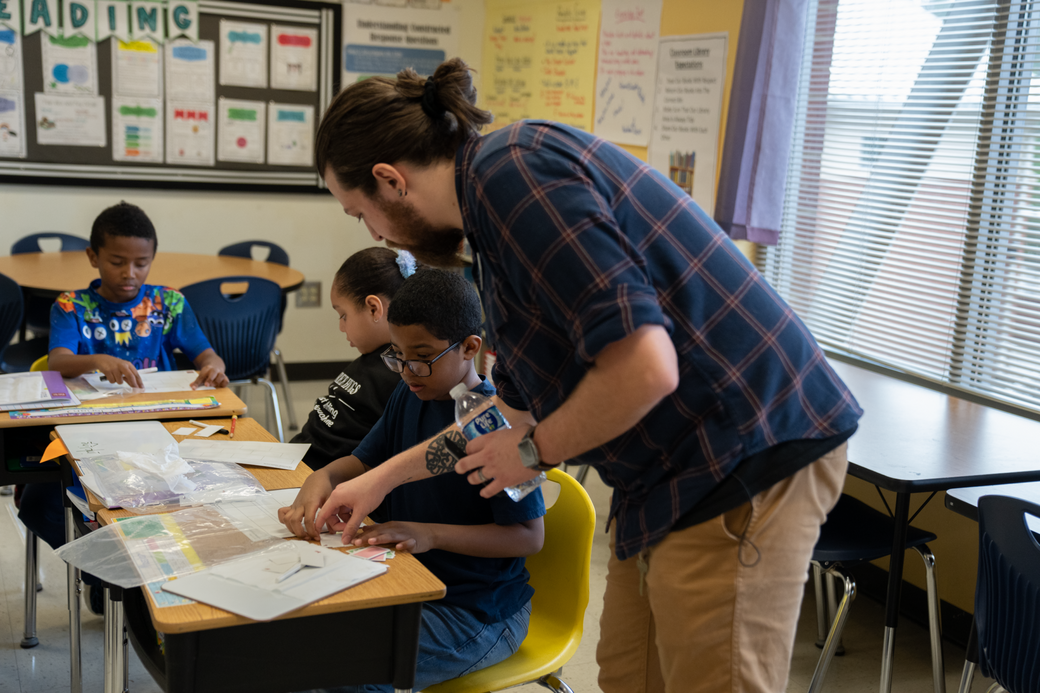 A reading teacher helps a student during a structured literacy lesson