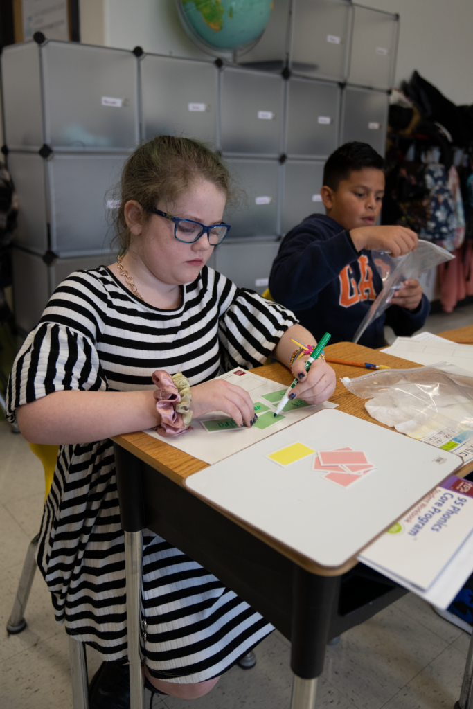 Phonics chips and spelling mat with a middle school reading student