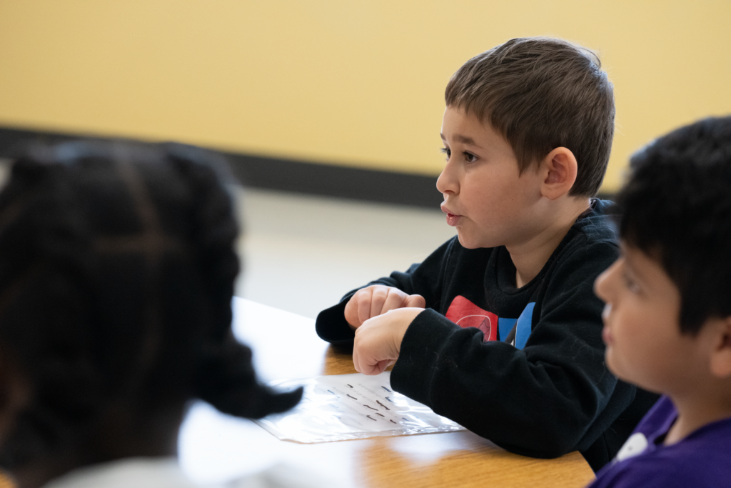 Elementary school boy feeling comfortable and connected to his small group and literacy instructor