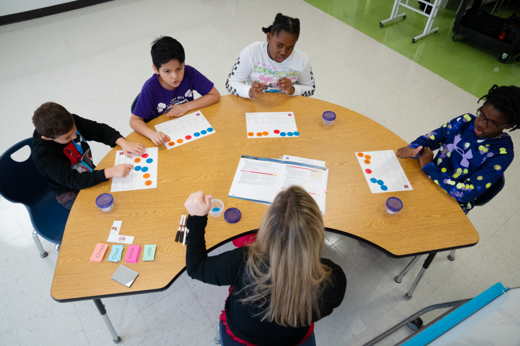 View of a small group using colorful manipulatives for reading instruction.