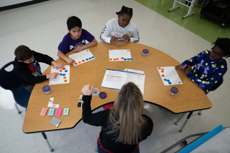 View of a small group lesson using chip kits and spelling mats