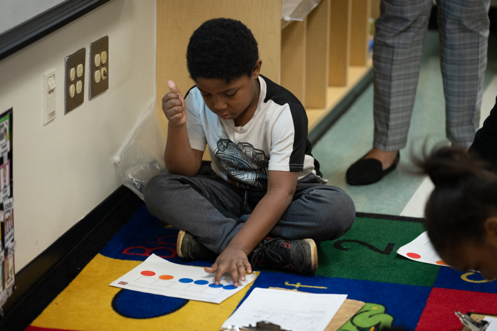 A boy learns to read with colorful manipulatives