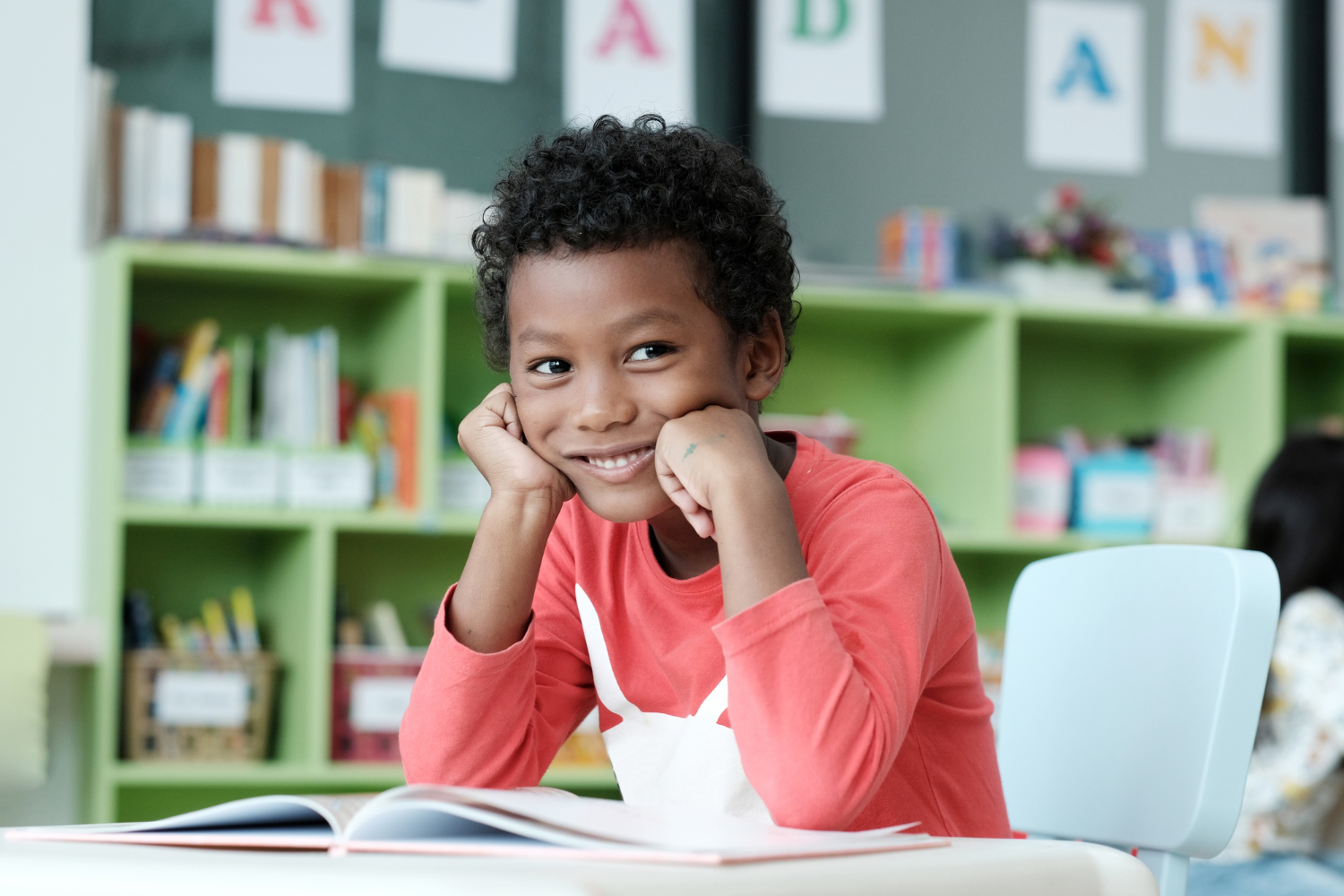 A smiling boy in a literacy-rich environment