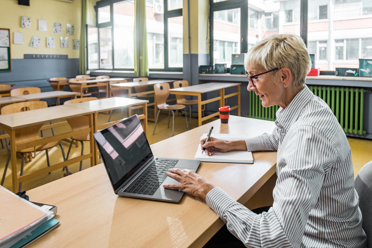 Teacher working on laptop in a classroom