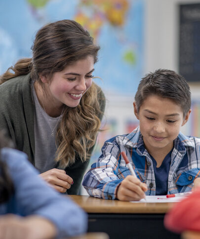 a young teacher helps her middle school student with his reading lesson