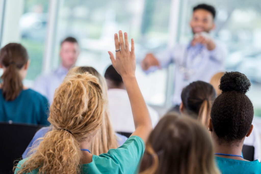 A professional training consultant calls on an eager literacy teacher during a professional learning session