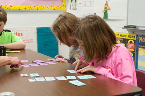 Kids learn to read using phonics cards to make their lessons concrete