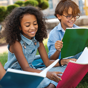 Middle school girl and boy outside enjoying their reading time