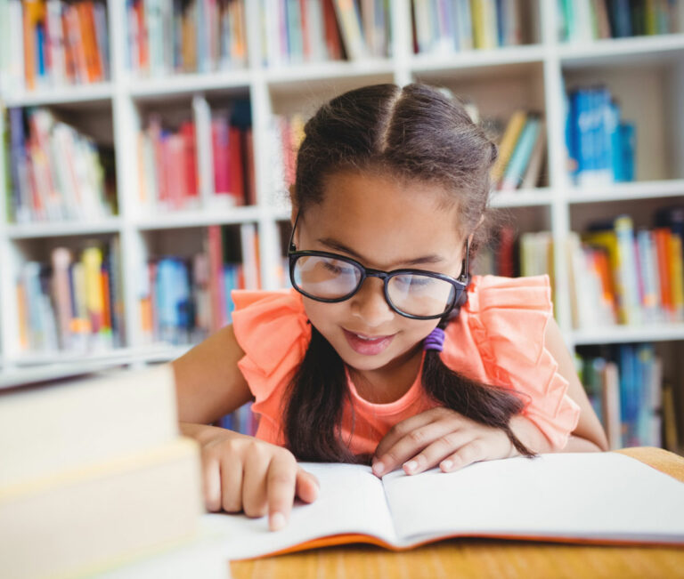 A middle school girls points to a word she is breaking into parts and reading