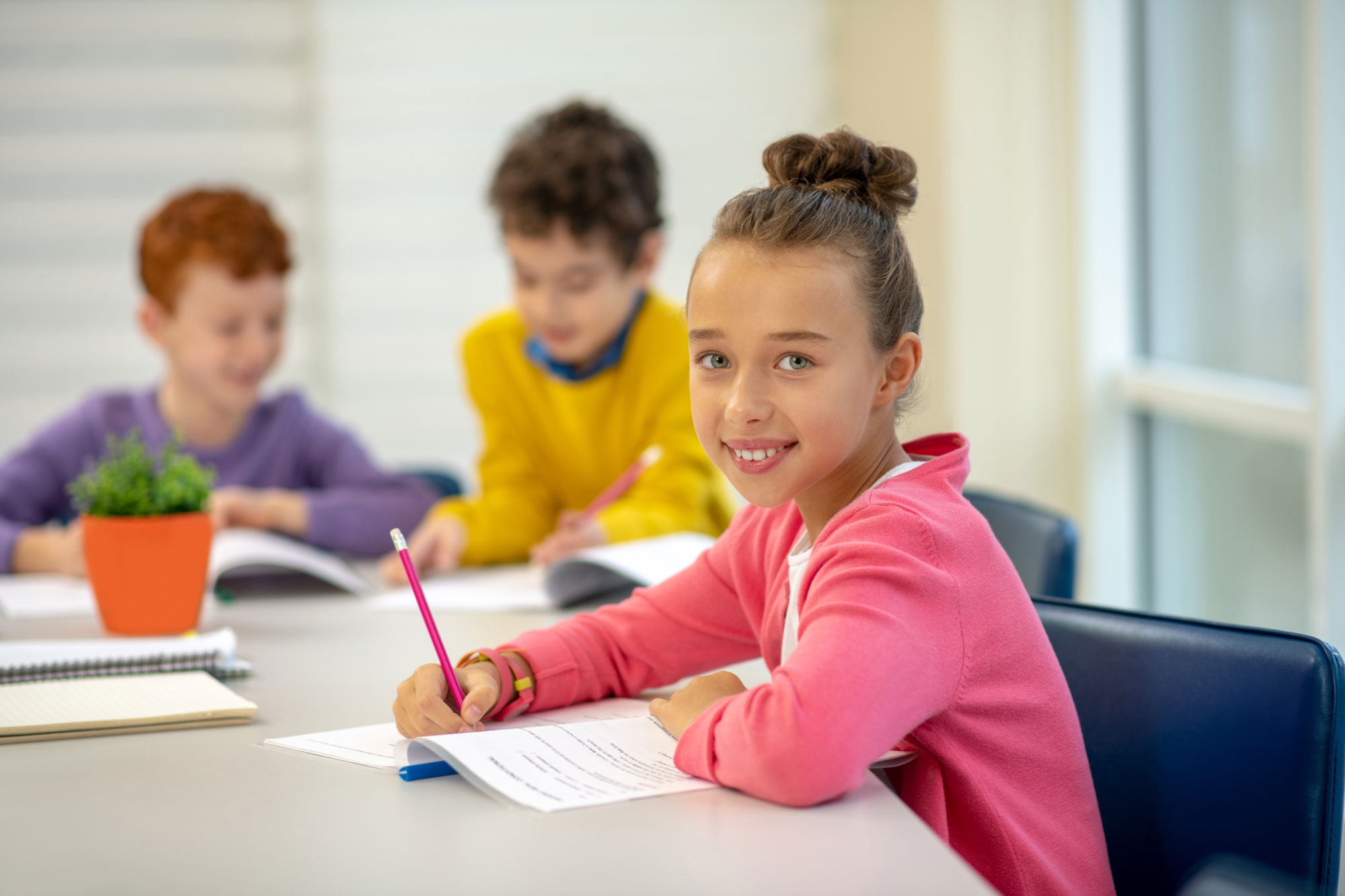 Middle school students in intervention small group classroom with pencils and phonics workbooks