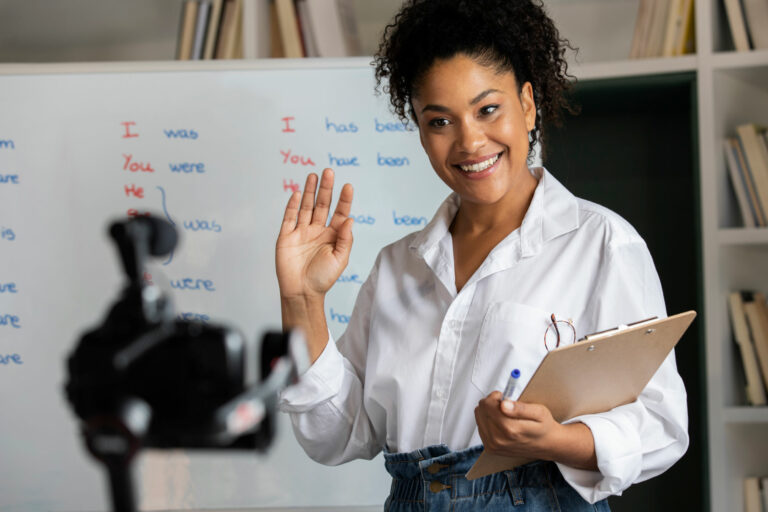 A reading teacher greeting her class in front of a white board with a phonics lesson