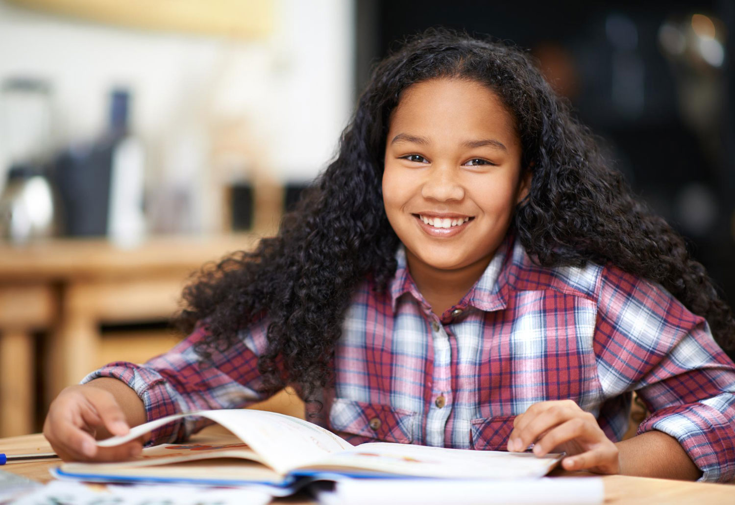 Middle school girl reading a book at a library desk