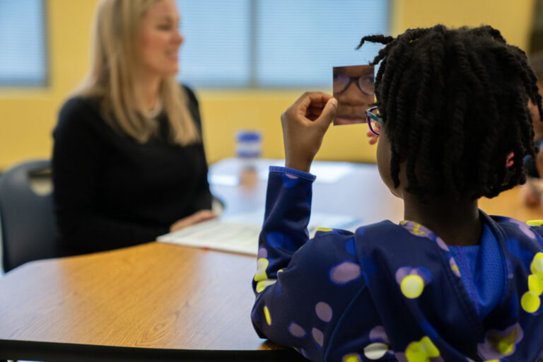 elementary school student uses mirror to sounds out words during phonics lesson