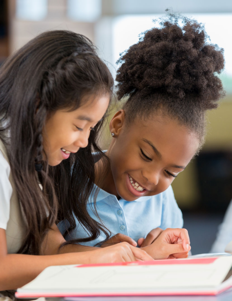 Two students reading a book together