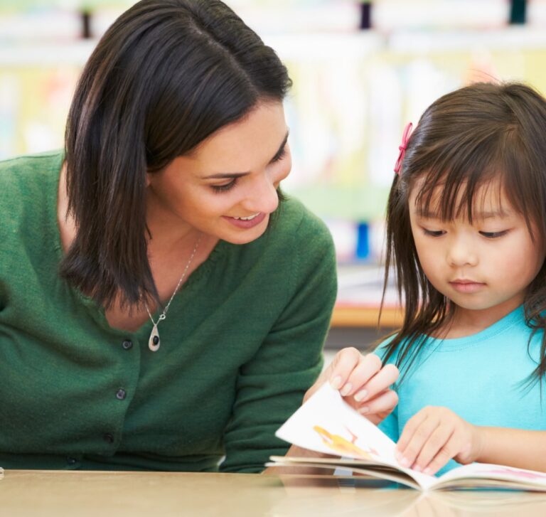 Adult and child reading together, focused on the book