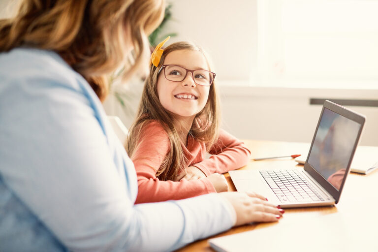 Student working with adult at laptop