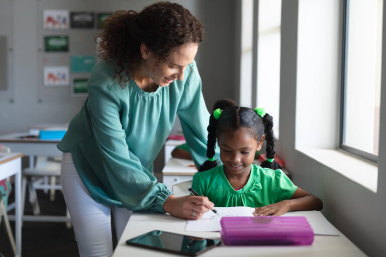 teacher assisting student with reading disability