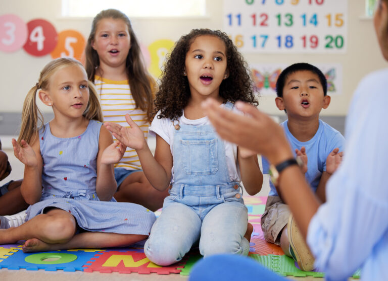 students in elementary classroom sounding out words together