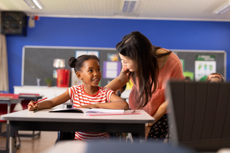 female teacher helping struggling student with reading lesson