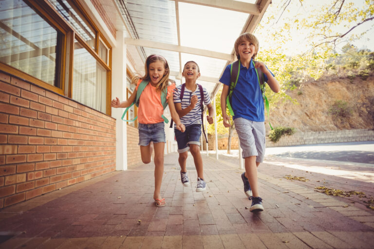 Happy school kids running in corridor