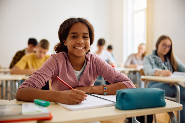 Happy African American high school student in the classroom looking at camera.
