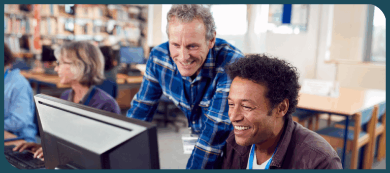 male literacy coach helping male educator train on computer