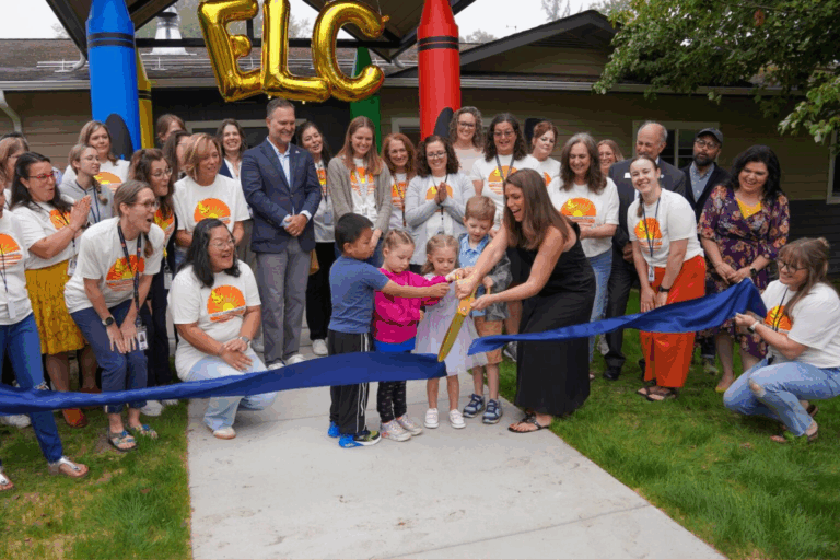 Early Learning Center Principal Meredith Macvean cuts the ribbon at the center’s opening with help from students