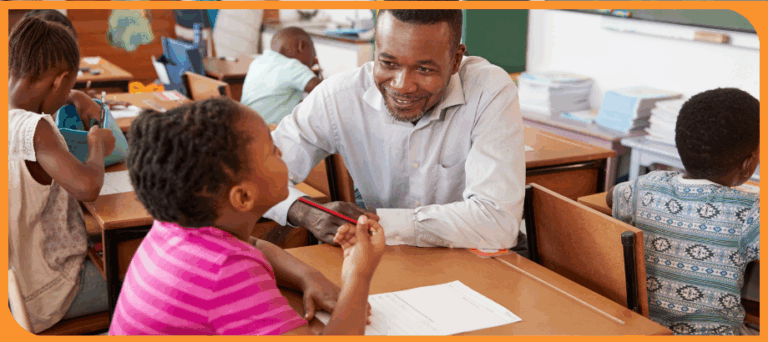 male teacher helping elementary student with literacy lesson