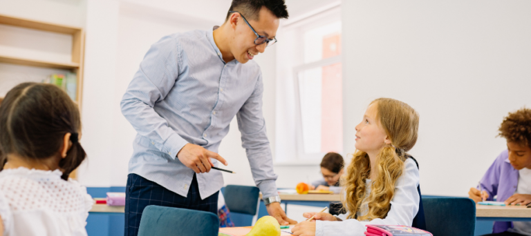 male middle school teacher helping student in class