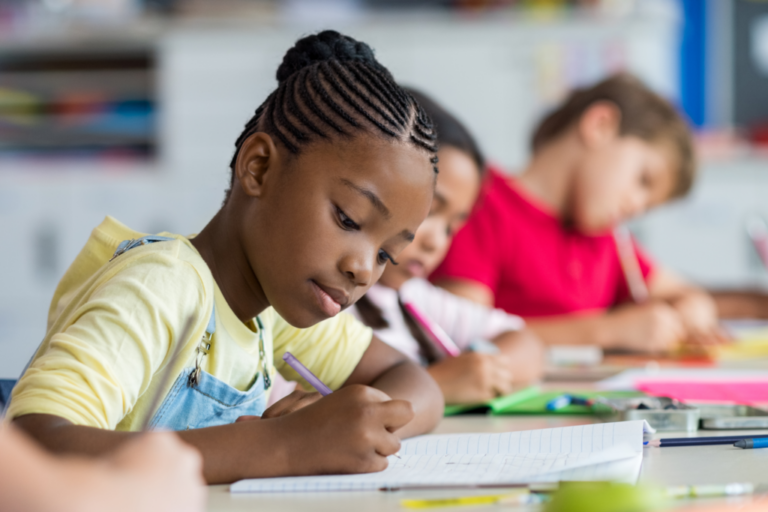 elementary kids writing in classroom